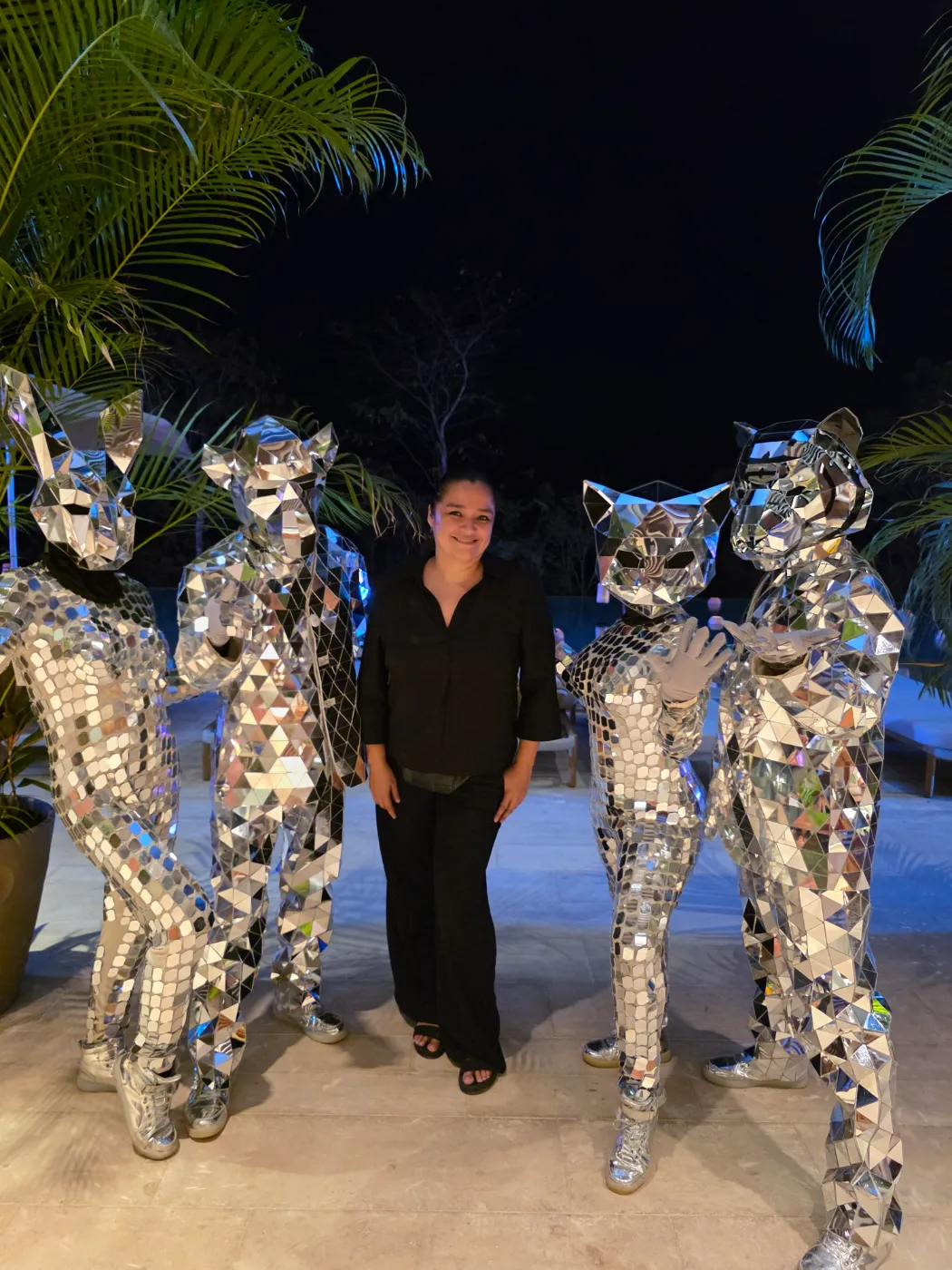 Laura Arriaga with mirror-suit performers at a poolside party