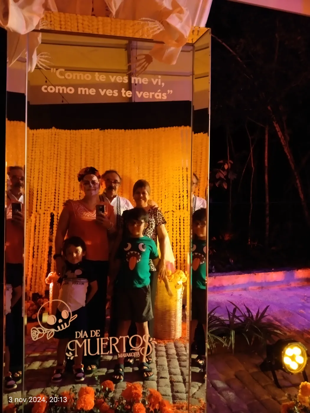 Guests posing in a Día de Muertos mirror photo frame