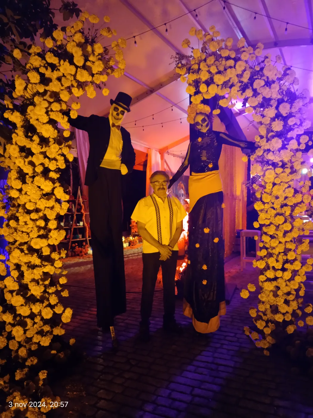 Catrina stilt walkers under marigold arches