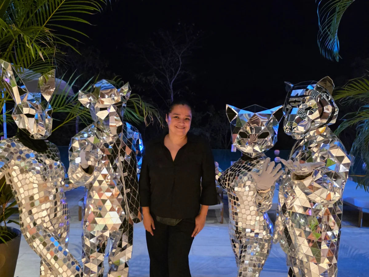 Laura Arriaga with mirror-suit performers at a Safari Feast poolside production