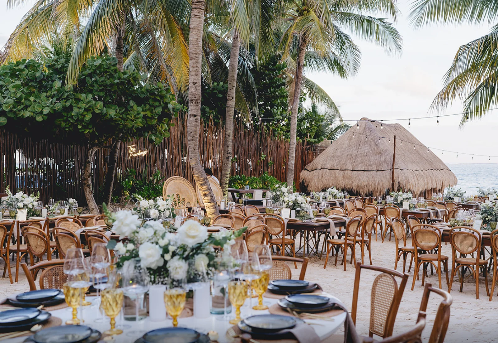Beachfront event tablescape under palm trees